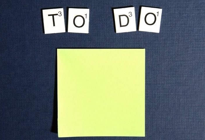 to do list written out in scrabble latter's above a post note